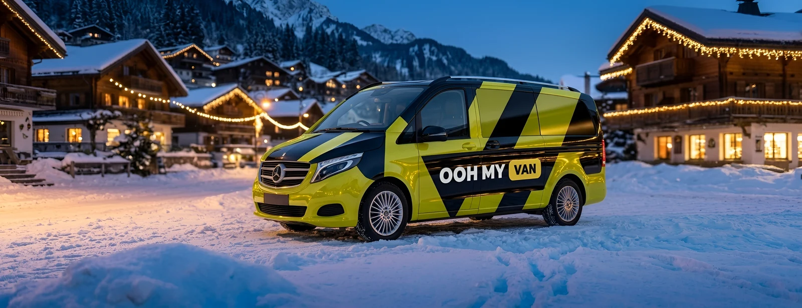 Van 9 places en total covering jaune-vert marqué OOH MY VAN, en station de ski à la tombée du jour